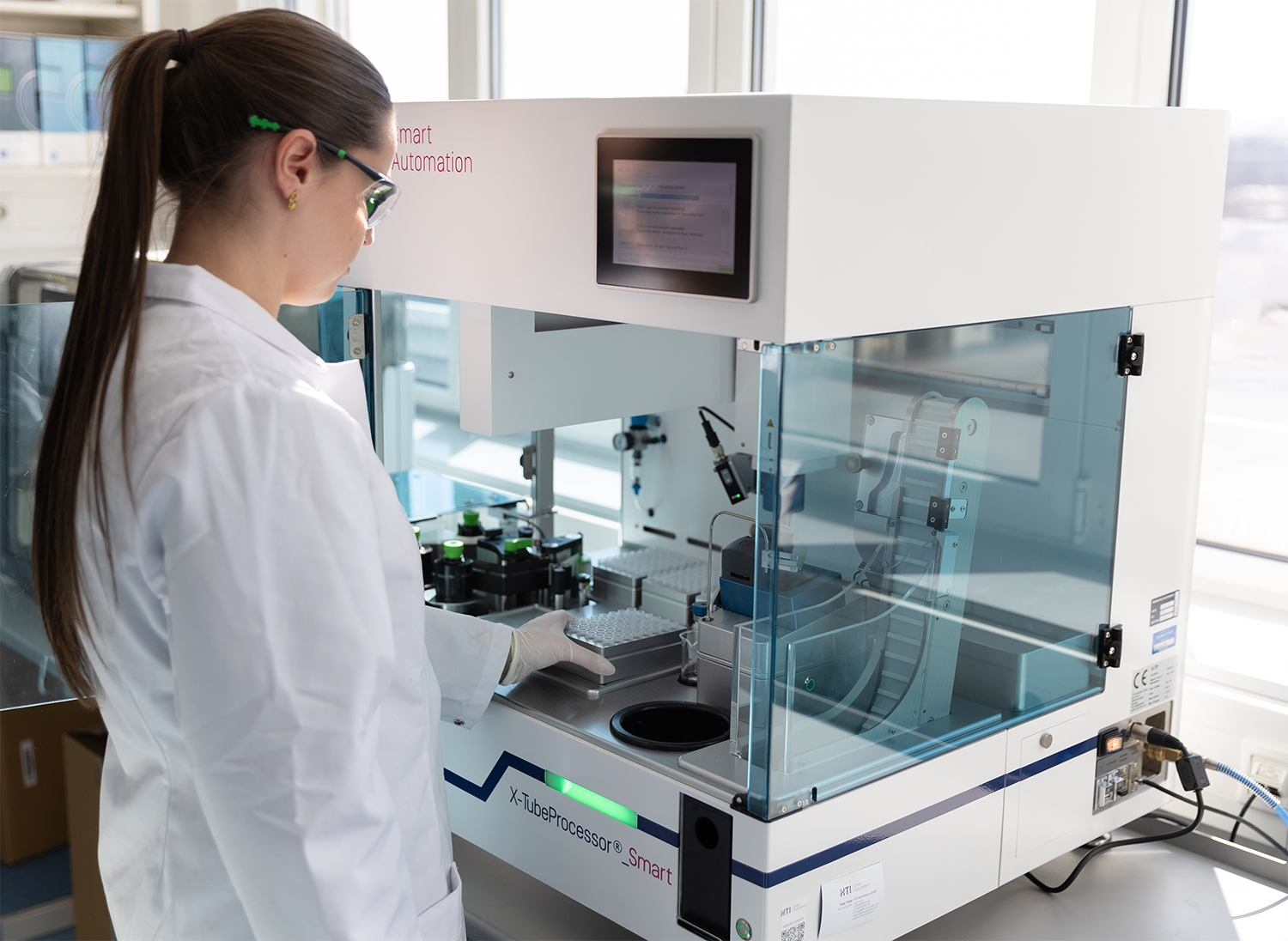Image shows a scientist using an automated tube processor